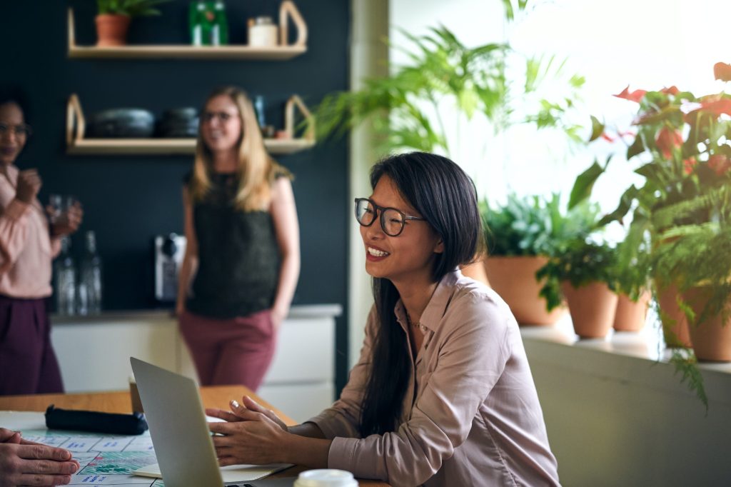 Smiling Asian businesswoman working at a table in an office